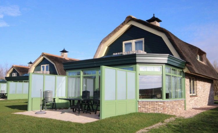 Terras van de 6 pers. luxe villa met serre in De Cocksdorp, Texel, perfect voor ontspanning op de Waddeneilanden.