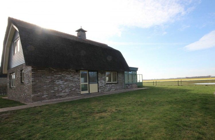 Rustieke buitenkant van de 6 pers. luxe villa met serre in De Cocksdorp, Texel, omgeven door natuur op de Waddeneilanden.