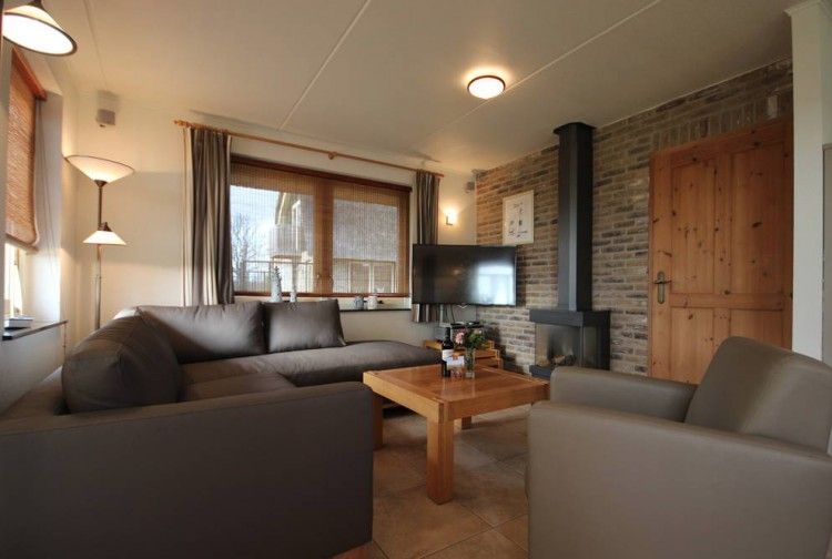 Comfortable living room in 6 pers. luxury wheelchair friendly villa, De Cocksdorp, Texel with sitting area and fireplace.