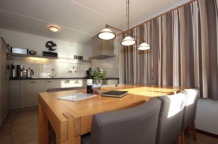 Dining area with wooden table in 6 pers. luxury wheelchair friendly villa, De Cocksdorp, Texel with lots of light.