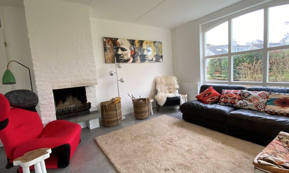 Gezellige woonkamer met open haard in Designhuis Volledig Vrij, een bungalow in De Cocksdorp, Texel.