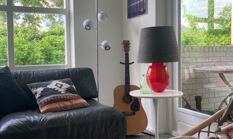 Comfortabele bank en gitaar in Designhuis Volledig Vrij bungalow, De Cocksdorp, Texel.