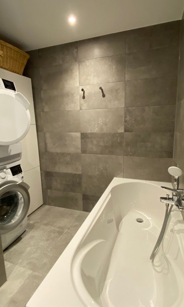 Luxe badkamer met bad en wasmachine in Designhuis Volledig Vrij bungalow, De Cocksdorp, Texel.