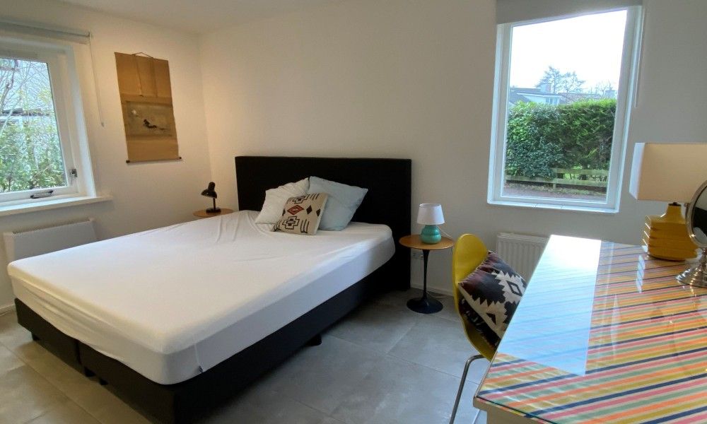 Stijlvolle slaapkamer met groot bed in Designhuis Volledig Vrij bungalow, De Cocksdorp, Texel.