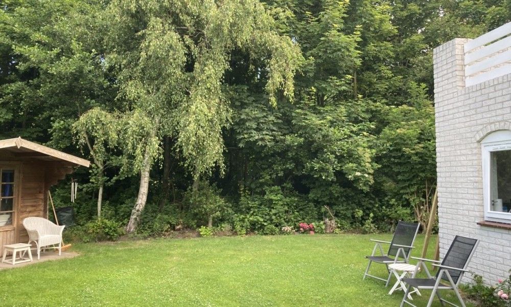Groene tuin met zitstoelen bij Designhuis Volledig Vrij bungalow, De Cocksdorp, Texel.