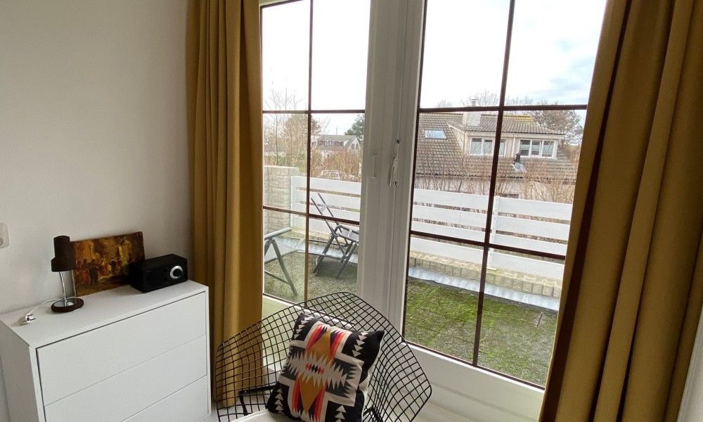 Knusse zithoek met uitzicht op balkon in Designhuis Volledig Vrij bungalow, De Cocksdorp, Texel.