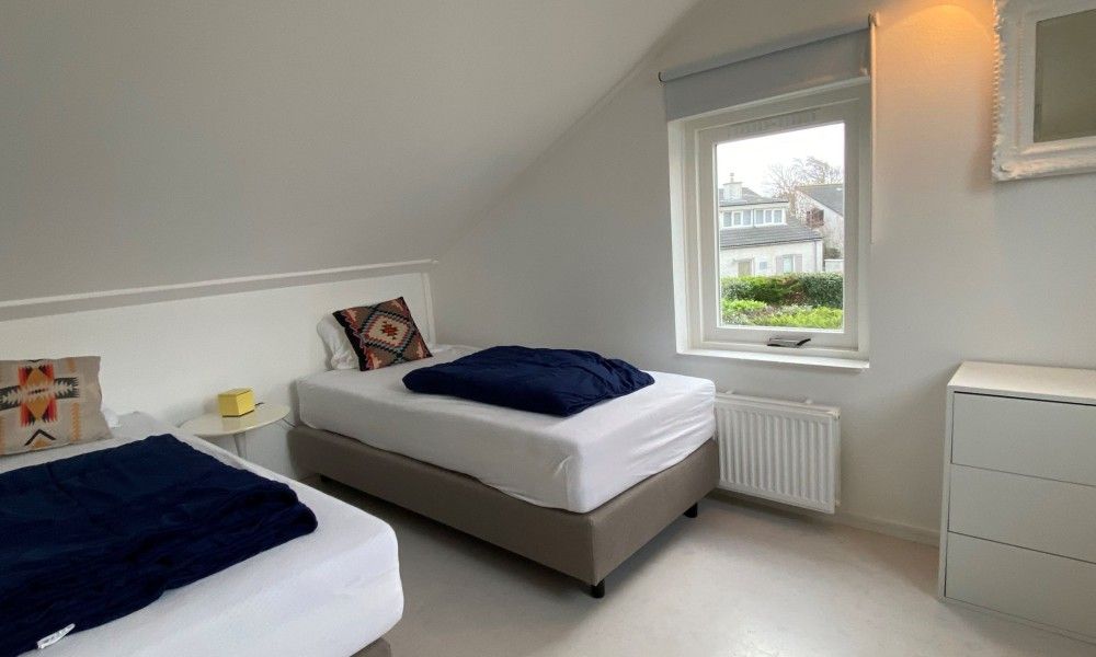 Slaapkamer met twee bedden in Designhuis Volledig Vrij bungalow, De Cocksdorp, Texel.
