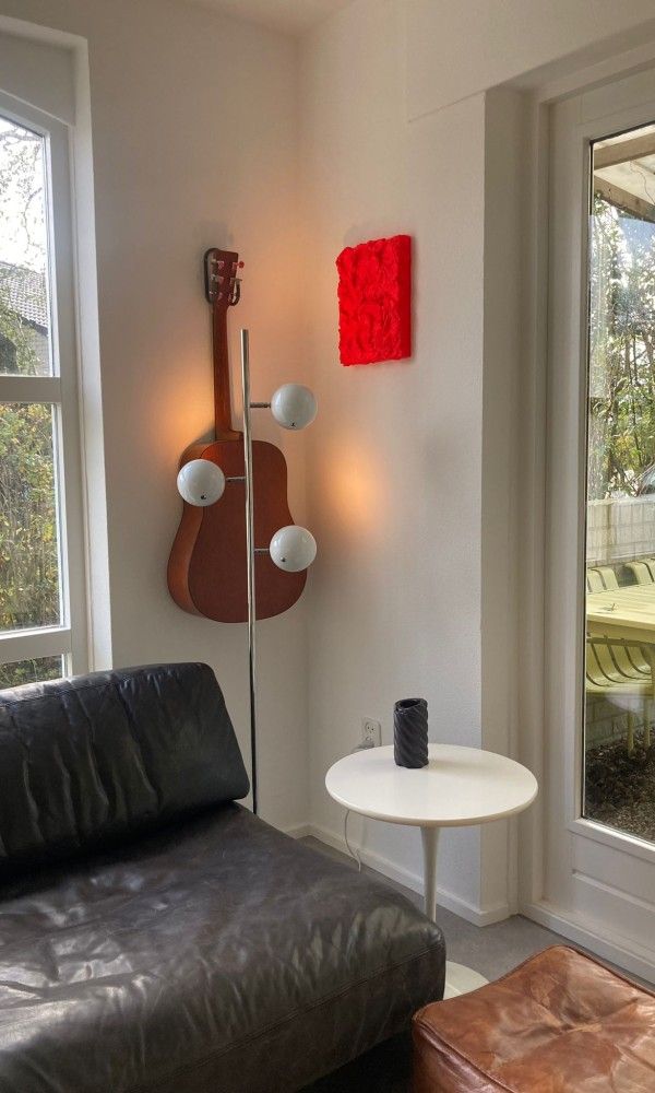 Zithoek met gitaar en decoratie in Designhuis Volledig Vrij bungalow, De Cocksdorp, Texel.