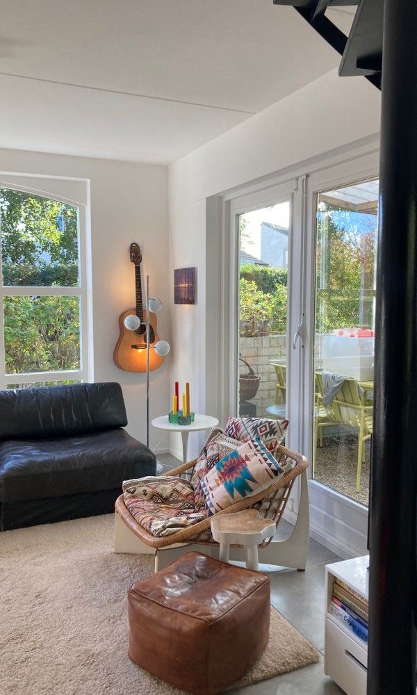 Knusse zithoek met decoratieve kussens in Designhuis Volledig Vrij bungalow, De Cocksdorp, Texel.