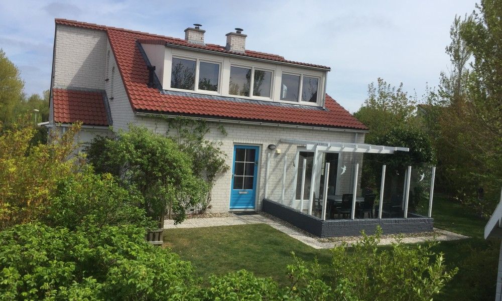 Krim 661 mit Sauna, Stuha und Grill, ein charmanter Bungalow in De Cocksdorp, Texel, umgeben von ueppiger Natur und einer einladenden Terrasse.
