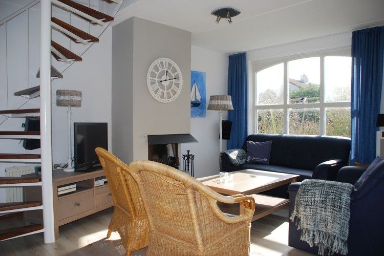 Gemuetliches Wohnzimmer von Krim 661 mit Sauna, Stuha und Grill in De Cocksdorp, Texel. Bequeme Sitzecke mit Kamin und Blick auf den Garten.