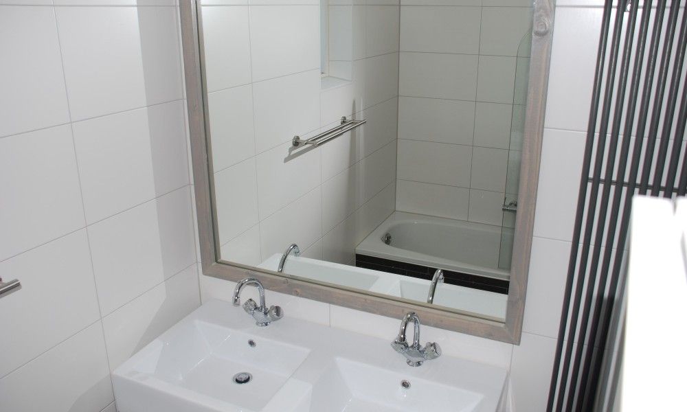 Modernes Badezimmer in Krim 661 mit Sauna, Stuha und BBQ, einem Bungalow in De Cocksdorp, Texel, mit stilvollen Waschbecken und einer geraeumigen Badewanne.