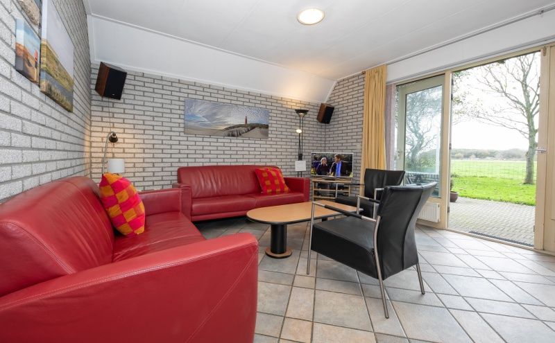 Gemuetliches Wohnzimmer im Ferienhaus Schelpenoord 129, De Cocksdorp, Texel mit bequemer Sitzecke.