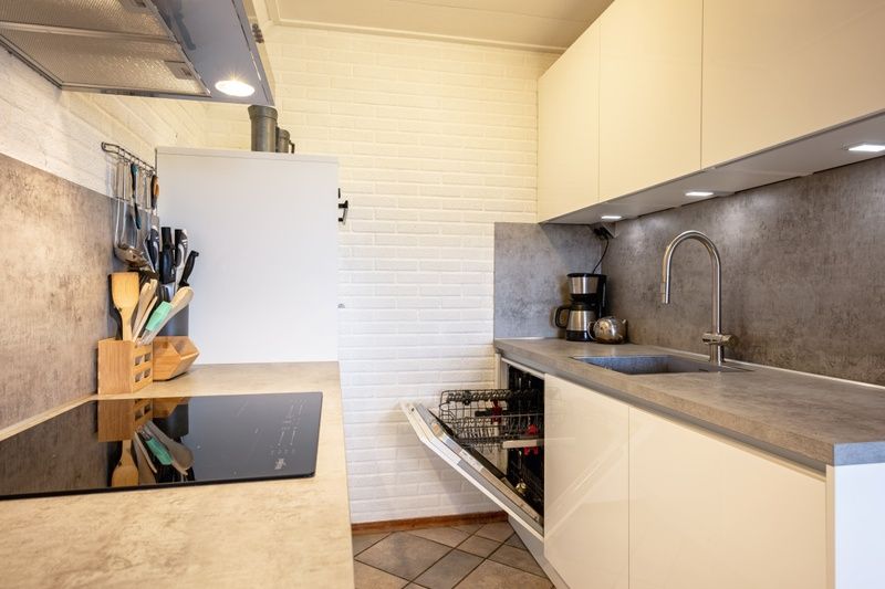 Praktische Kueche im Ferienhaus Schelpenoord 129, De Cocksdorp, Texel mit Spuelmaschine und Kochfeld.