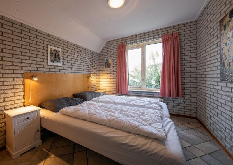 Gemuetliches Schlafzimmer im Ferienhaus Schelpenoord 129, De Cocksdorp, Texel mit Doppelbett.