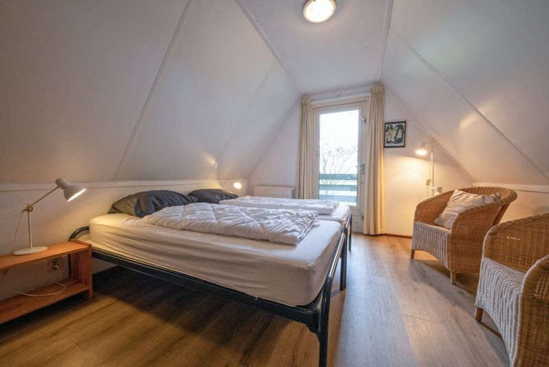 Gemuetliches Schlafzimmer im Ferienhaus Schelpenoord 129, De Cocksdorp, Texel mit Balkonblick.