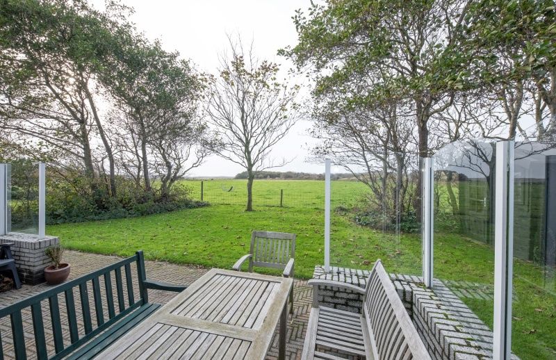 Blick von der Terrasse des Ferienhauses Schelpenoord 129, De Cocksdorp, Texel auf gruene Felder.