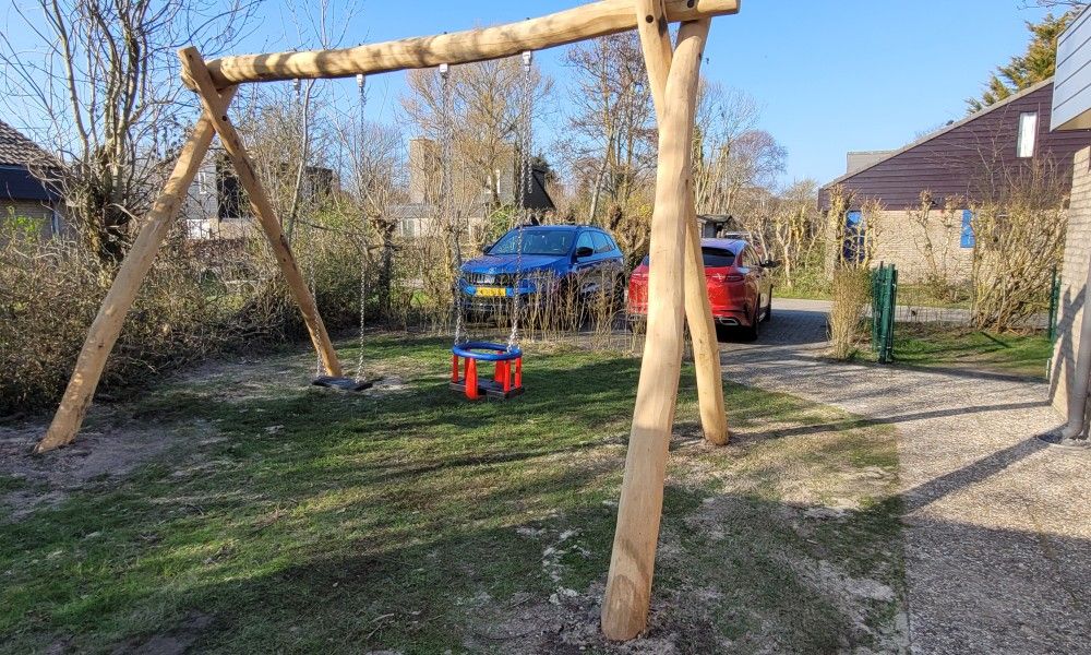 Speelterrein met schommel bij Het Eiland Gevoel, een vakantiehuis in De Cocksdorp op Texel, omringd door natuur en rust.