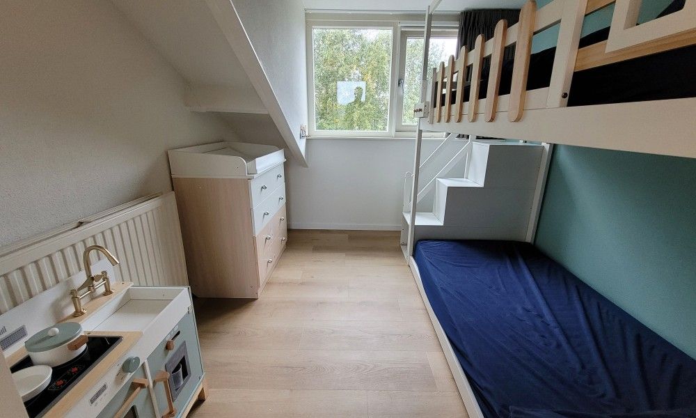 Gezellige kinderkamer in vakantiehuis Het Eiland Gevoel, De Cocksdorp, Texel. Comfortabele stapelbedden en uitzicht op groene natuur.