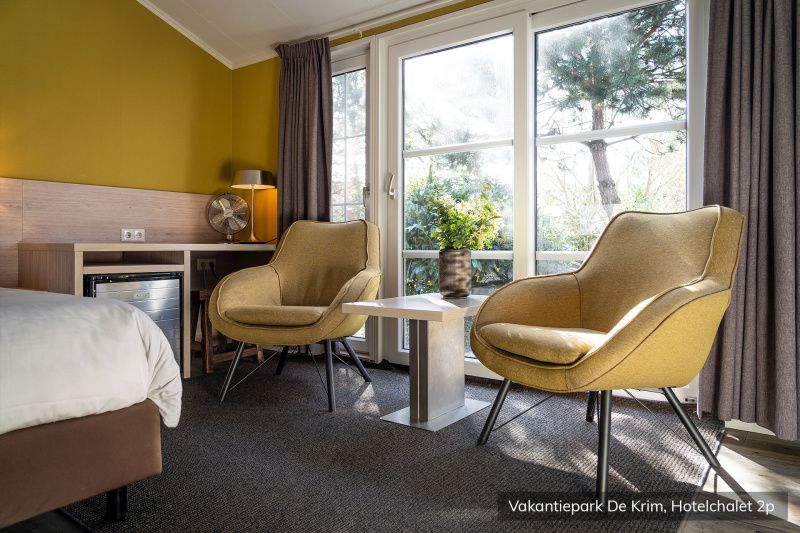 Gemuetliche Sitzecke im luxurioesen 2-Personen-Hotelchalet auf Texel, mit Blick auf die gruene Umgebung von De Cocksdorp.