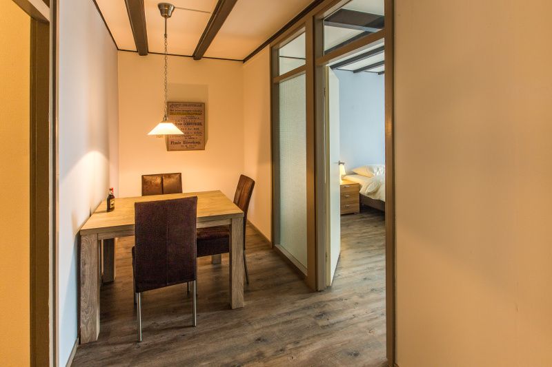 Essecke im Typ X-7 Ferienhaus De Cocksdorp Texel mit Holztisch und Stuehlen