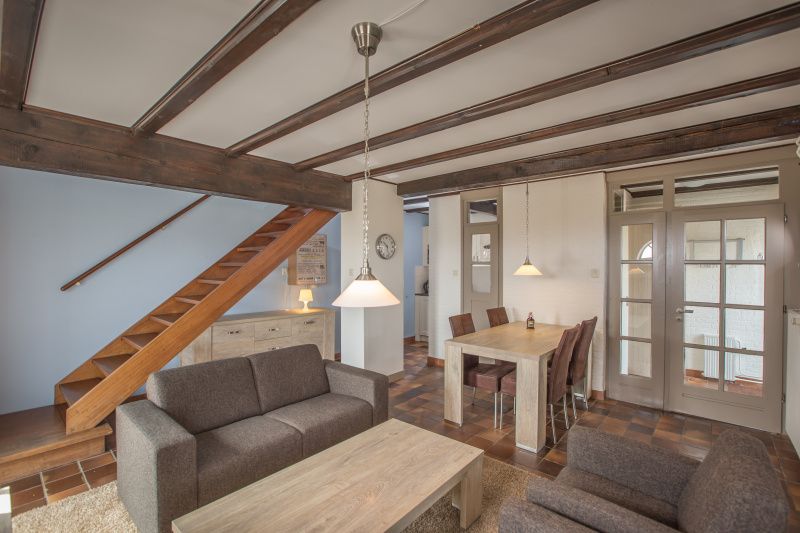 Dining area and stairs in Type T-3 vacation home, De Cocksdorp, Texel, with wooden elements.