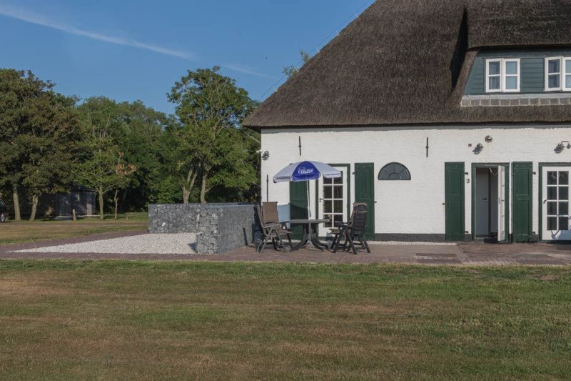 Terrace with seating at Type T-3 vacation home, De Cocksdorp, Texel, ideal for outdoor relaxation.