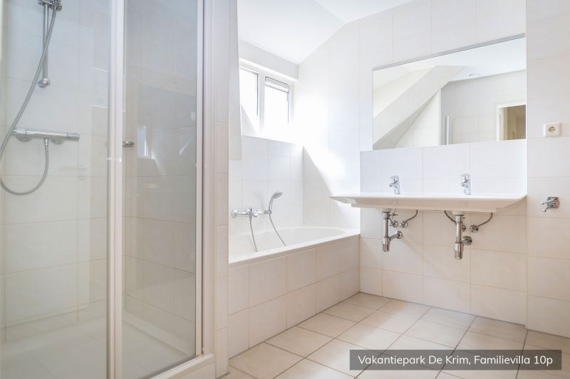 Ruime badkamer met douche en bad in Familievilla 10 persoons, De Cocksdorp, Texel.