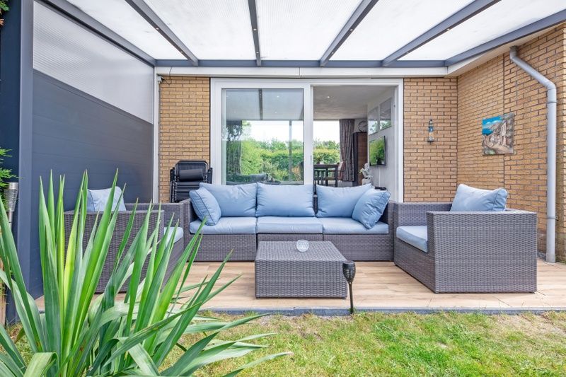 Covered terrace with seating at Bungalow Duin aan Zee Texel, Bungalowpark Tamarisk, in De Cocksdorp.