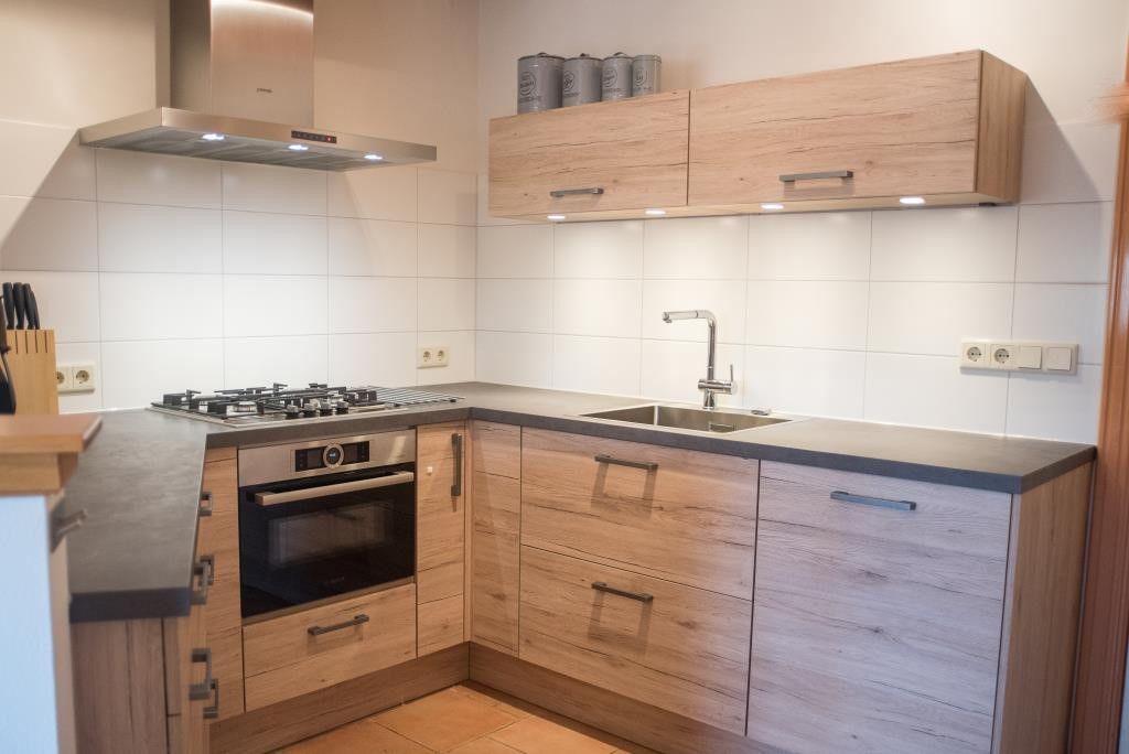Moderne keuken in Velduil vakantiehuis, De Cocksdorp, Texel met houten afwerking.
