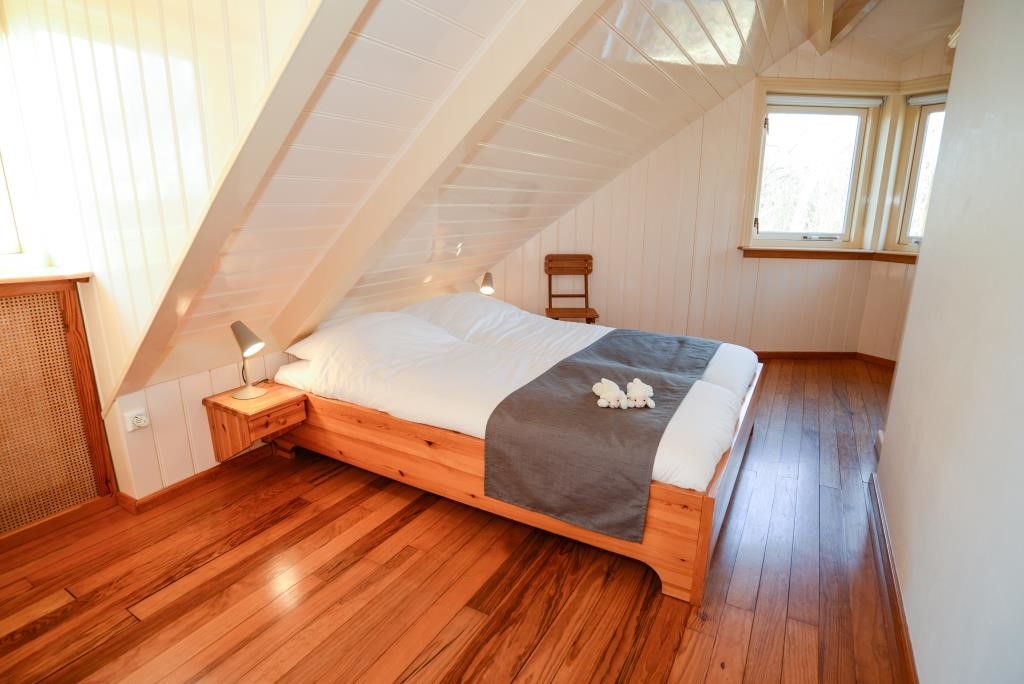 Slaapkamer in Velduil vakantiehuis, De Cocksdorp, Texel met houten vloer en dakraam.