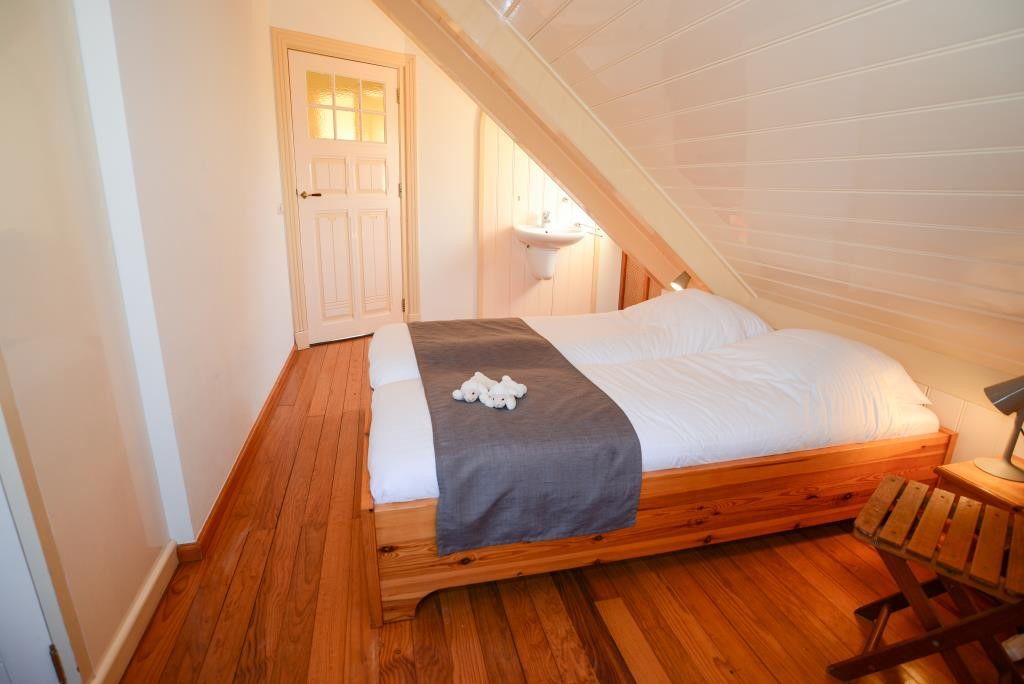 Slaapkamer met houten details in Velduil vakantiehuis, De Cocksdorp, Texel.