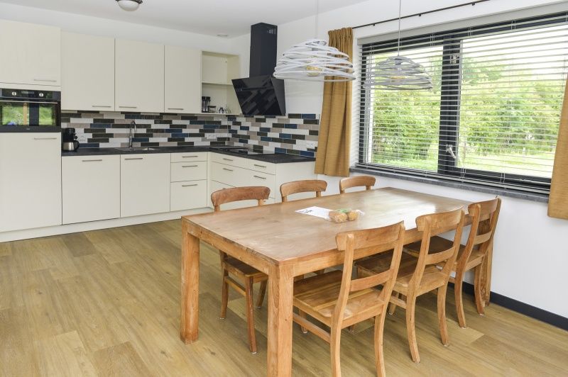 Geraeumige Essecke in De Postschipper in De Cocksdorp Texel mit Holztisch und Stuehlen.