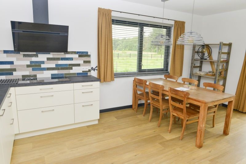 Kueche und Essbereich im Ferienhaus De Postschipper auf Texel mit Blick auf den Garten.