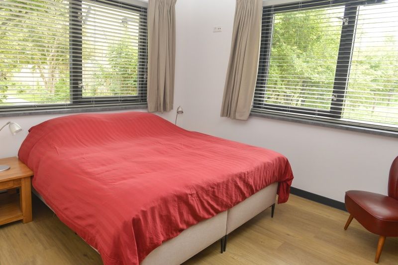 Schlafzimmer mit Doppelbett im Ferienhaus De Postschipper auf Texel mit Tageslicht.