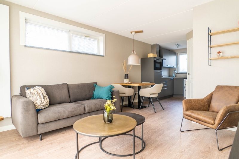 Cozy sitting area and kitchen in vacation home Type D Kikkertstraat, De Cocksdorp, Texel, for a relaxing stay.