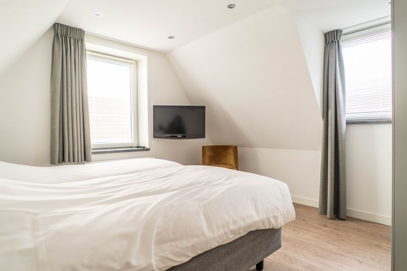 Bright bedroom in Type D Kikkertstraat, De Cocksdorp, Texel, with comfortable bed and serene atmosphere.