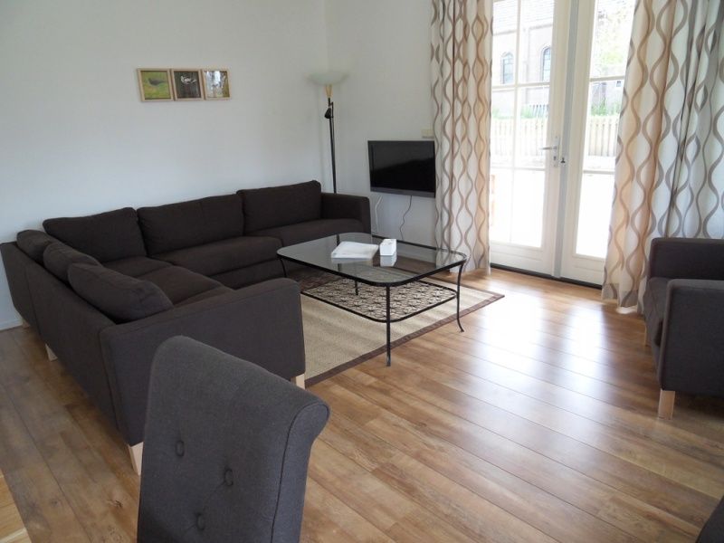 Gemuetliches Wohnzimmer des Ferienhauses Typ 7 - 2107 in De Cocksdorp Texel mit grosser Sitzecke und Tageslicht.