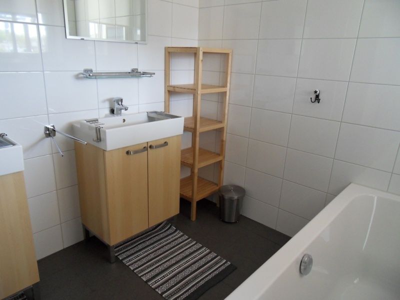 Modernes Badezimmer in Typ 7 - 2107 Ferienhaus De Cocksdorp Texel mit grossem Waschbecken und Badewanne.