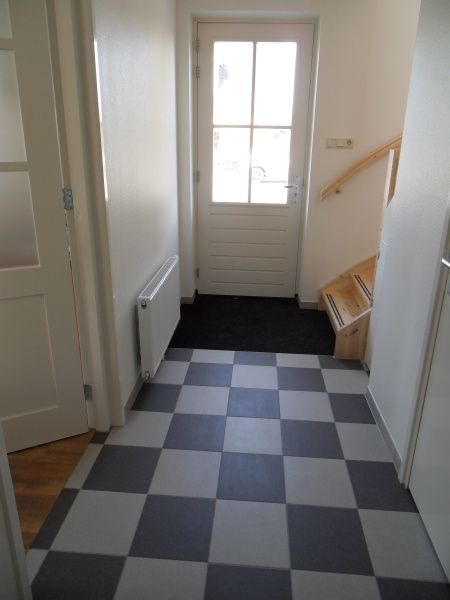 Eingangshalle des Ferienhauses Typ 7 - 2107 De Cocksdorp Texel mit stilvollem Fliesenboden und Treppenhaus.