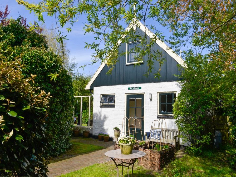 The Wulpenlied vacation home in De Cocksdorp, Texel, surrounded by greenery and flowers.