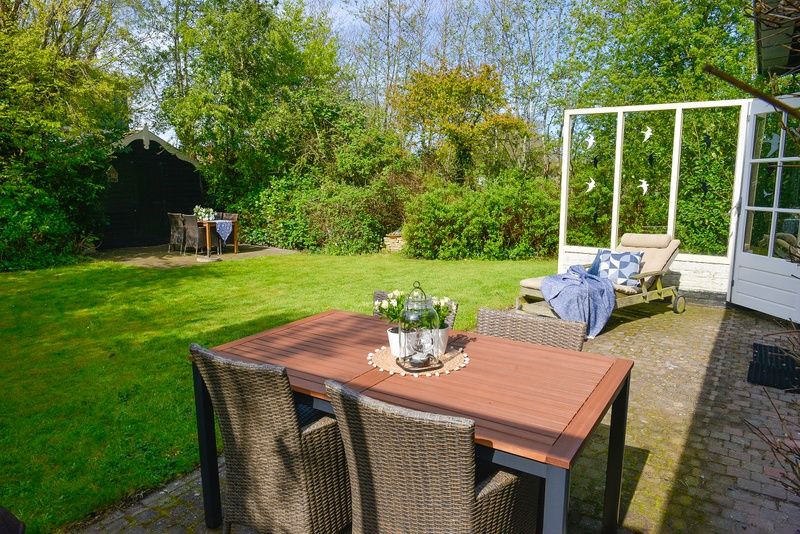 Spacious garden with sitting area at Het Wulpenlied vacation home, De Cocksdorp, Texel.