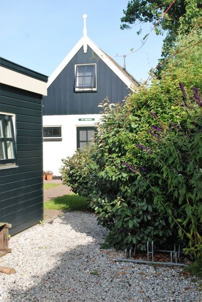 Entrance to Het Wulpenlied vacation home in De Cocksdorp, Texel among greenery.