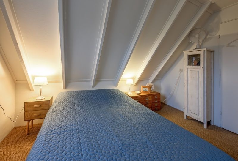 Comfortable bedroom with wooden furniture in Het Wulpenlied, De Cocksdorp, Texel.