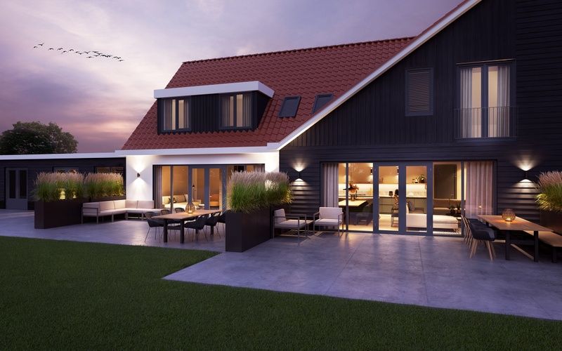 Illuminated evening view of 6 person vacation home in De Cocksdorp Texel with terrace.