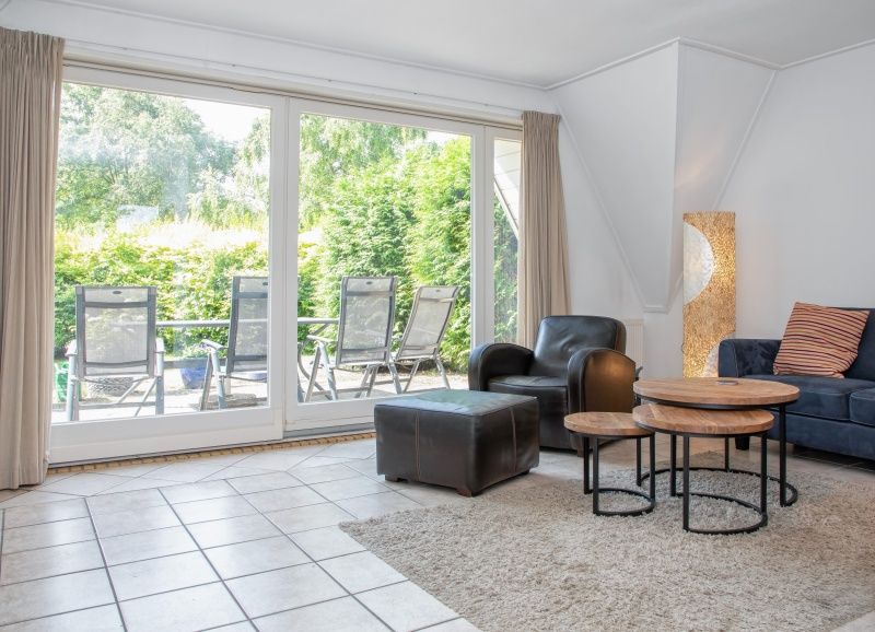 Blick aus dem Wohnzimmer des Ferienhauses Slufterduin 076, De Cocksdorp, Texel, mit Zugang zur Sonnenterrasse des Wattenmeeres.