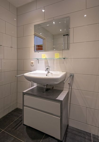Funktionelles Waschbecken im Ferienhaus Slufterhoek 102, De Cocksdorp, Texel mit Spiegelschrank und glatter Oberflaeche.