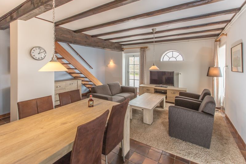 Gezellige woonkamer in Type T-4 vakantiehuis, De Cocksdorp, Texel met houten balken.
