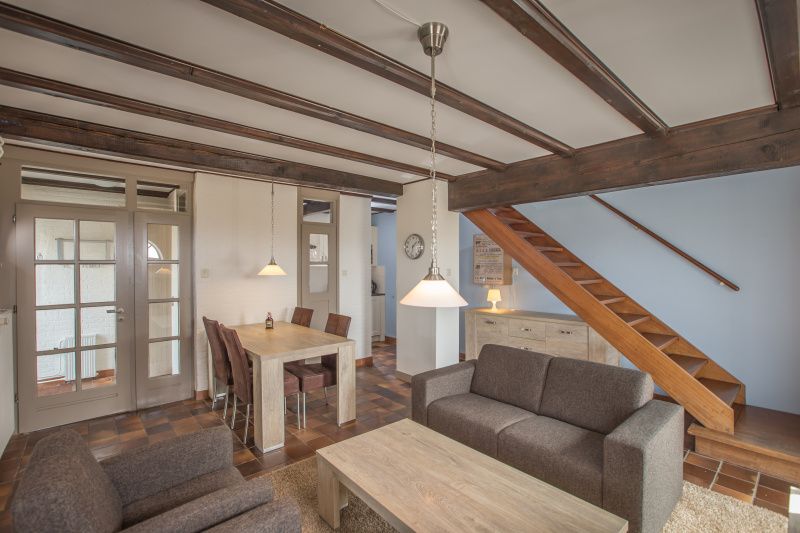 Eetkamer en zithoek in Type T-4 vakantiehuis, De Cocksdorp, Texel met open trap.