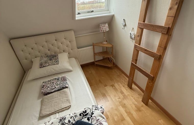 Stylish bedroom with decorative ladder in Holiday cottage in De Cocksdorp, Texel, Wadden Islands.